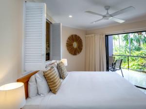 a bedroom with a large white bed and a large window at Anchorage in Hamilton Island