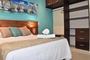 1 dormitorio con cama y pared azul en Condo Lux Xareni en Playa del Carmen