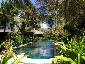 a swimming pool in the middle of a garden at Full Moon Beach Resort in Mui Ne