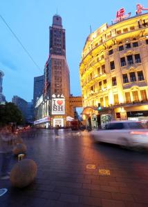 فندق Seventh Heaven في شانغهاي: شارع المدينة فيه مباني وسيارة تمر