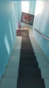 a stairway in a room with a painting on the wall at Homestay Melaka Sungai Udang (TSF Qaseh) in Kampong Baharu Sungai Udang +15 photos
