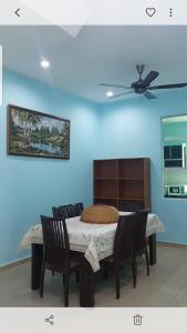 a dining room table with two chairs and a ceiling fan at Homestay Melaka Sungai Udang (TSF Qaseh) in Kampong Baharu Sungai Udang