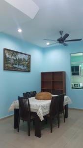 a dining room table with chairs and a ceiling fan at Homestay Melaka Sungai Udang (TSF Qaseh) in Kampong Baharu Sungai Udang