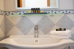 un lavandino in bagno con due asciugamani e uno specchio di Thalassa Apartments a Nydri