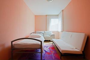 ハノーファーにあるPrivate Roomsのベッド2台と椅子が備わる小さな客室です。