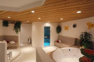 a living room with a tub and a couch at Hotel Landhaus Feldmeier ***S in Oberammergau