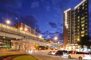 K Hotel Taipei Dunnan في تايبيه: مدينة في الليل مع سيارات تقف في شارع