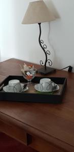 a tray with two tea cups and a lamp on a table at La jolie chambre in Javrezac +5 photos
