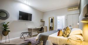um quarto com uma cama, uma secretária e uma televisão em Hlangana Lodge em Oudtshoorn