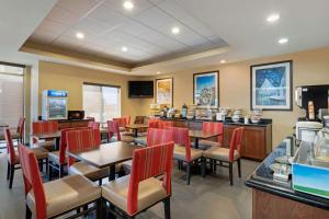 a restaurant with tables and chairs and a bar at Comfort Inn & Suites Port Arthur-Port Neches in Port Arthur