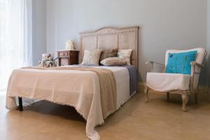 a bedroom with a large bed and a chair at filobrocante in Torre Santa Susanna