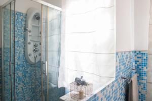 a bathroom with a shower with blue and white tiles at filobrocante in Torre Santa Susanna