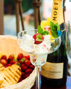 un bicchiere di vino con macedonia di frutta e una bottiglia di vino di Respect Hotel a Pavlodar