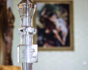 un primo piano di una bottiglia di profumo d'argento davanti a una foto di Respect Hotel a Pavlodar
