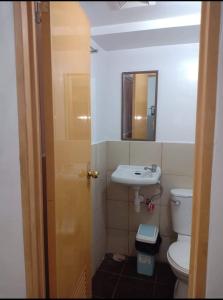 a bathroom with a toilet and a sink and a mirror at BUDGET FRIENDLY CONDO-STUDIO UNIT in Cebu City +21 photos