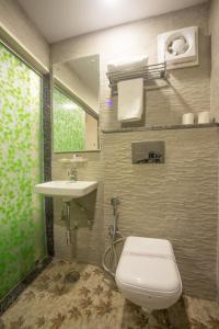 a bathroom with a toilet and a sink at Delhi Guest House in New Delhi