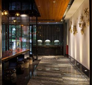 a room with a table and vases on a wall at Paco Hotel Gangding Metro Guangzhou-Free Shuttle Bus fir Canton Fair in Guangzhou