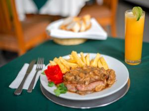 a plate of steak and fries and a drink on a table at Hotel Escala Siglo XXI in Mexico City