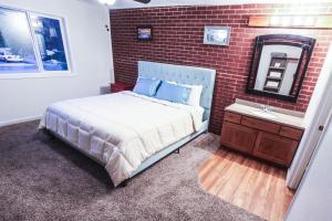 - une chambre avec un lit et un mur en briques dans l'établissement The Wing at Kingston East, à Rexburg