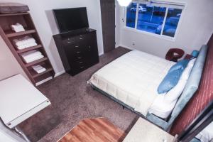 1 dormitorio con 1 cama, vestidor y TV en The Wing at Kingston East en Rexburg