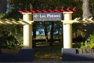 a sign for a less planes sign in a park at Hôtel Restaurant les Platanes in Montfaucon-en-Velay