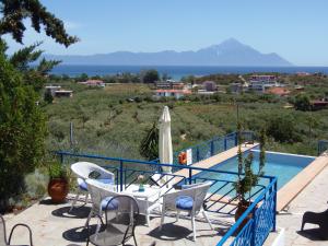 un patio con tavolo e sedie accanto alla piscina di Sartivista Bed & Breakfast a Sárti