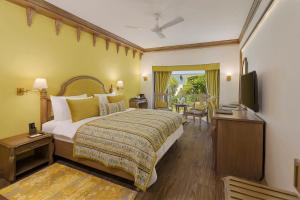 a hotel room with a bed and a television at Ramada by Wyndham Mussoorie Mall Road in Mussoorie