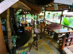 a restaurant with tables and chairs in a room at Eriono guest house Bukit lawang in Bukit Lawang