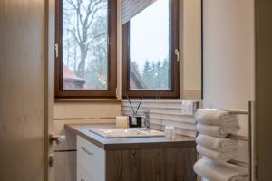 a bathroom with a sink and a window and towels at Amberton Villas in Karklė