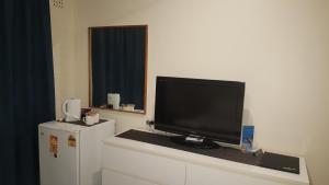 a television sitting on top of a counter next to a refrigerator at Lockleys Hotel in Adelaide