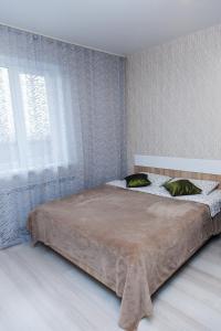 ノヴォシビルスクにあるApartament Antonina near by Marriott hotelのベッドルーム1室(枕2つ、窓付)
