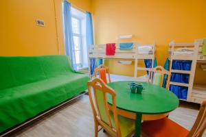 Zimmer mit einem Tisch, einem Sofa und einem Bett in der Unterkunft Na Italyanskoy Mini-Hotel in Sankt Petersburg