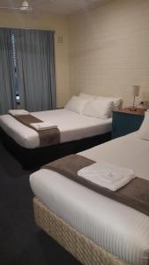Deux lits dans une chambre d'hôtel avec des lictslictslictstritistes dans l'établissement Lockleys Hotel, à Adélaïde