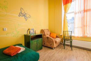ein Schlafzimmer mit einem Bett und einem Stuhl sowie einem Schmetterling an der Wand in der Unterkunft Na Italyanskoy Mini-Hotel in Sankt Petersburg