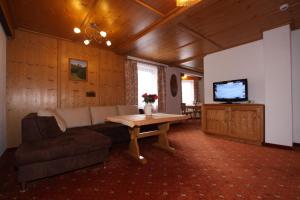 a living room with a couch and a table and a tv at Waldhof in Gerlos