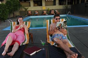 een man en een vrouw zittend in tuinstoelen bij een zwembad bij Giritale Hotel in Polonnaruwa