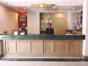 a woman standing at the counter of a restaurant at The Executive Hotel Lahad Datu in Lahad Datu