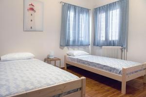 two beds in a room with a lighthouse on the wall at Pnyka Apartment 2 in Athens