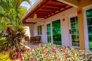 a porch of a house with flowers and plants at Solare SAI Ecohotel in San Andrés