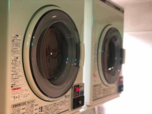 two washing machines are shown in a kitchen at Hotel New White House in Rumoi