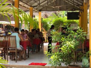 a group of people sitting at tables in a restaurant at Blossoming Romduol Boutique in Siem Reap