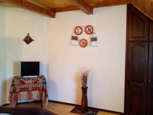 Habitación con TV y platos en la pared. en Pensiunea Turlas Maria, en Săliştea de Sus