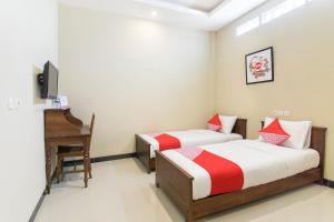 A bed or beds in a room at SUPER OYO 890 Dewi Fortuna Guest House