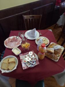 a table with a red table cloth with food on it at London Cafè in Castelnovo neʼ Monti