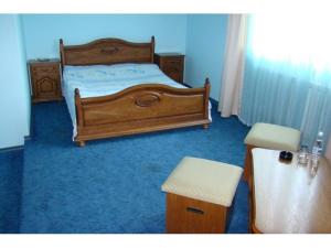 a bedroom with a bed, chair, and desk at Dvorik in Chernivtsi