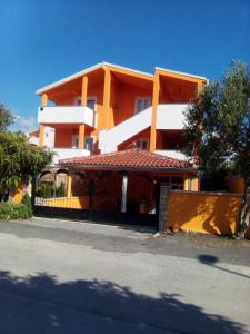 ein orangefarbenes Gebäude mit einem Tor davor in der Unterkunft Apartments Batarilo in Biograd na Moru