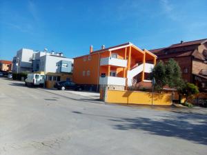 pomarańczowo-biały budynek po stronie ulicy w obiekcie Apartments Batarilo w Biogradzie na Moru