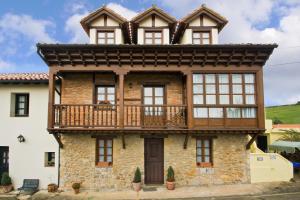 stary dom z balkonem na górze w obiekcie Vivienda Casa Luisa w mieście Comillas