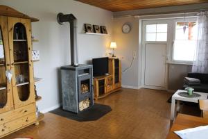 a living room with a wood stove in it at Haus am Rötenberg in Grafenhausen