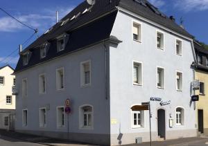 a white building with a black roof on a street at Ferienwohnung Crames in Trier